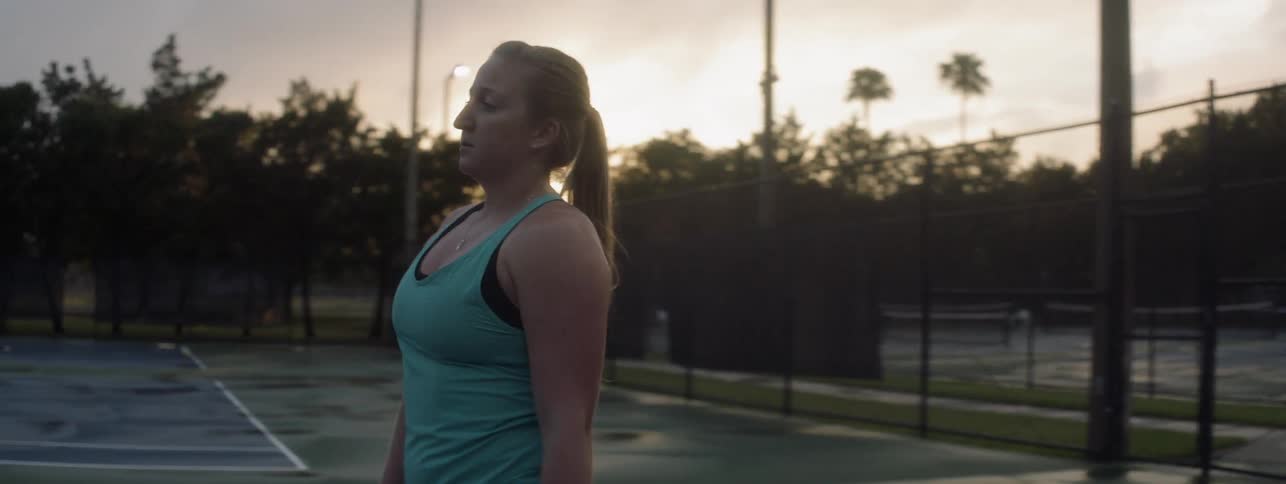 A woman serves a tennis ball