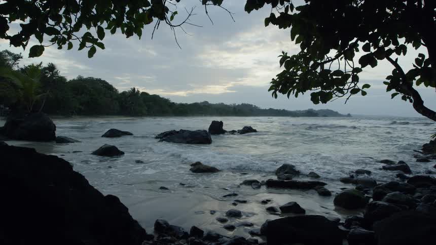 Ocean waves flow over and around rocks near shore