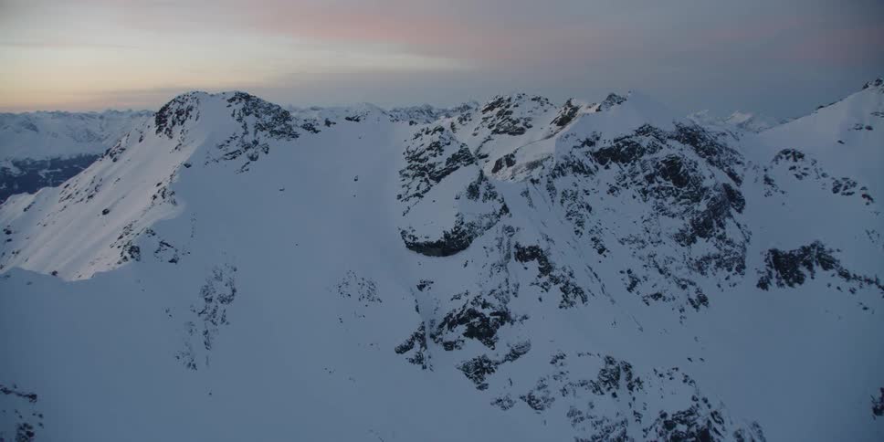 The snow is high along the side of the mountains