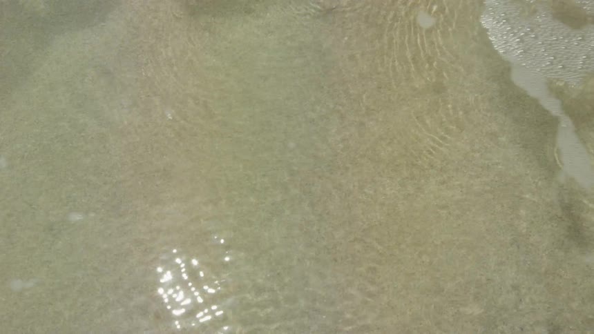 The ocean tide moving in over the sand on the beach