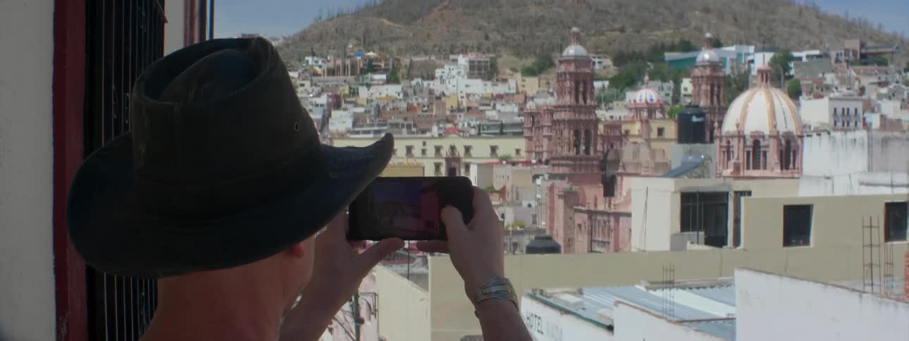 A man takes a picture from the window
