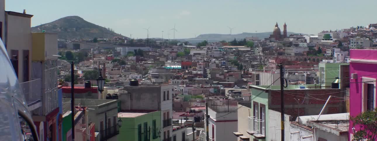 A large city at daytime on a clear day with mountains in the background
