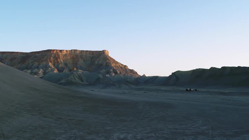 The sun sets over a desert landscape