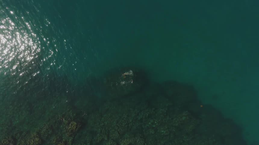 The water is clear with rocks underneath