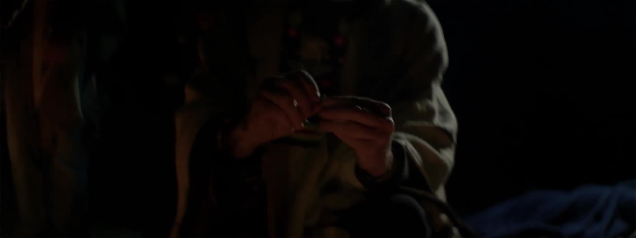 A person twists something in their hand in the dark
