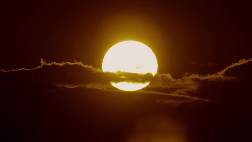 Clouds float in front of the sun