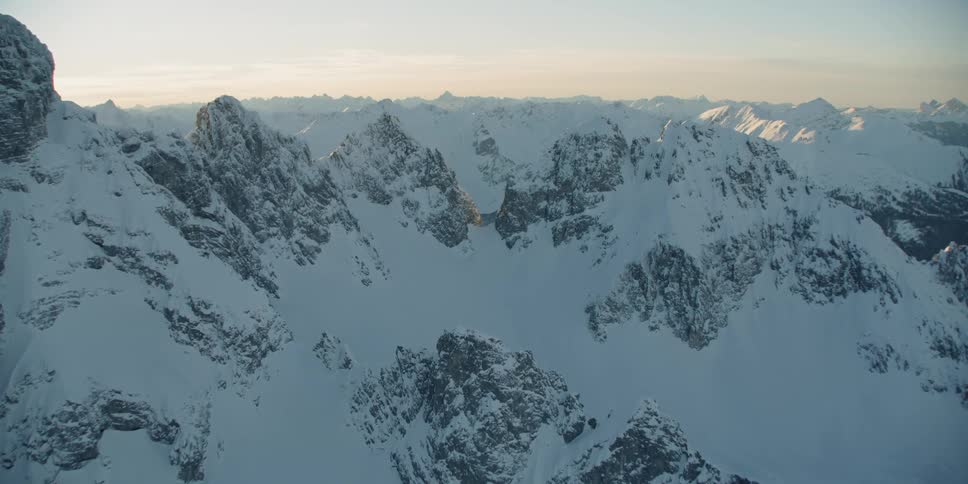 The sun shines on snow covered ridges and peaks