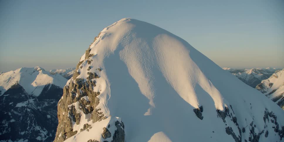 Snow covers the rocky mountain top