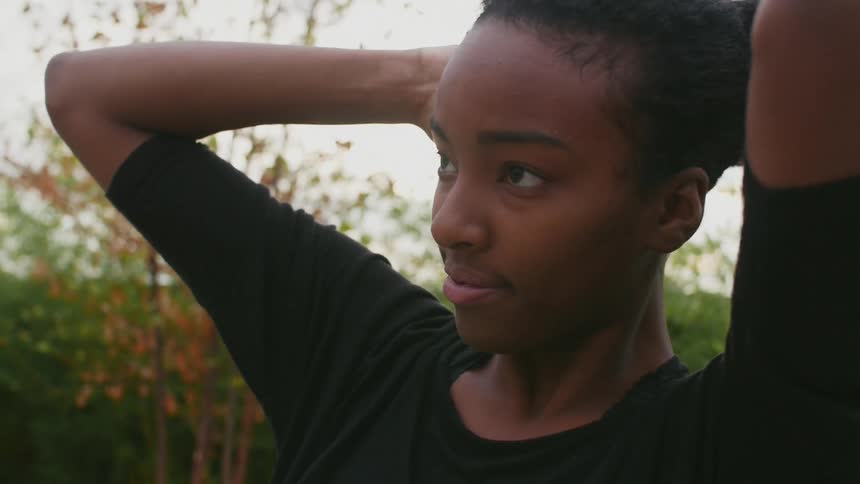 A girl tying her hair back