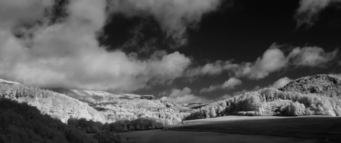 White clouds pass above the hills