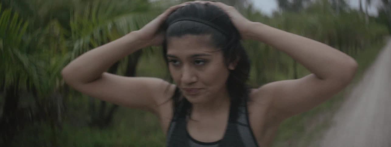 Woman stops to catch her breath while running on a dirt road