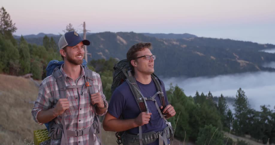 Two men hiking up on a mountain near a lake