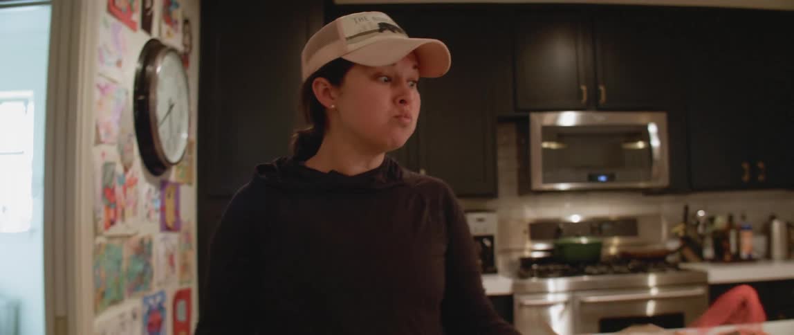 Woman eats takeout while feeding her young children