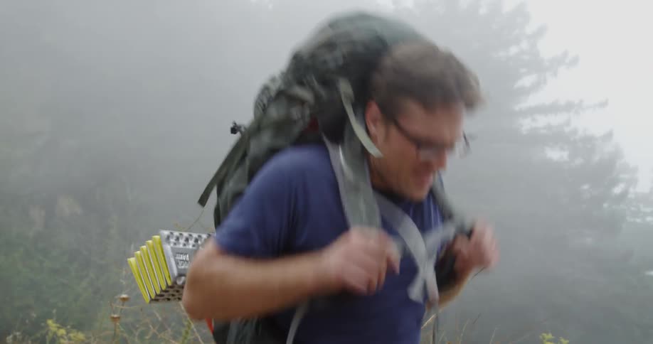 Man hikes in foggy mountains
