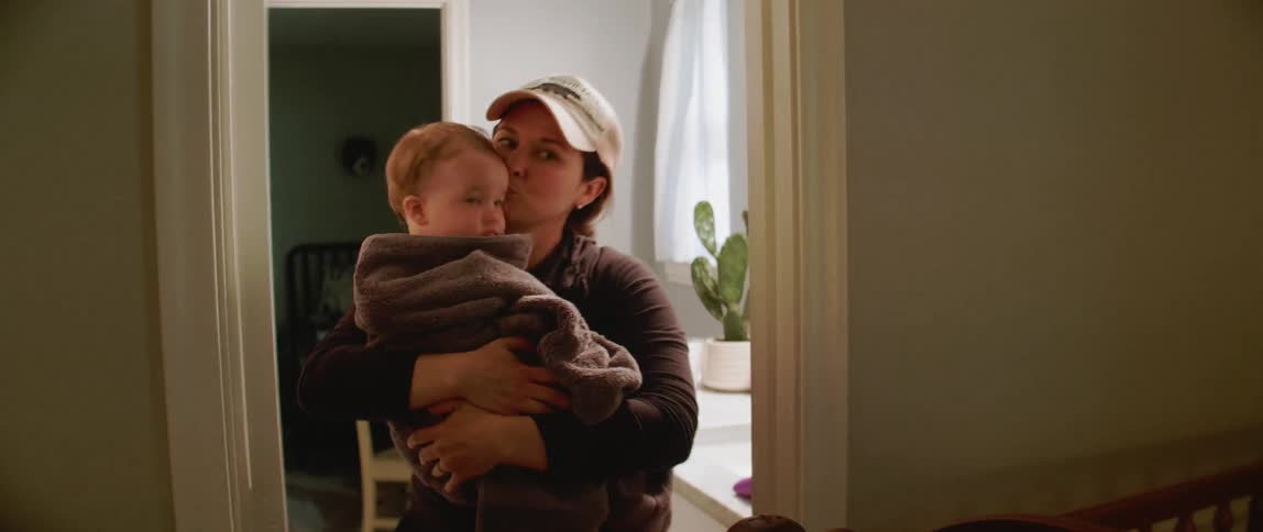 A woman carries a baby from the bathtub