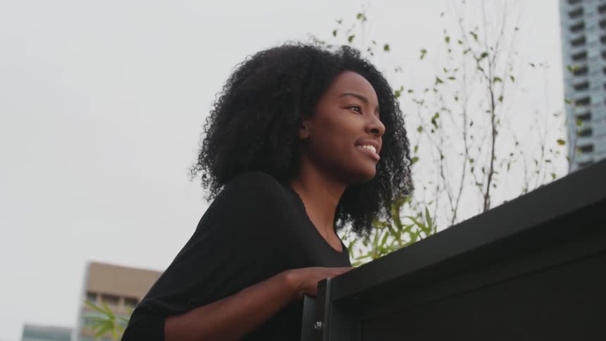 Woman standing outside looks over a city