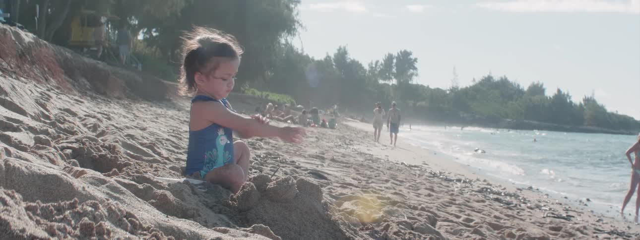 Child plays in the sand on the beach