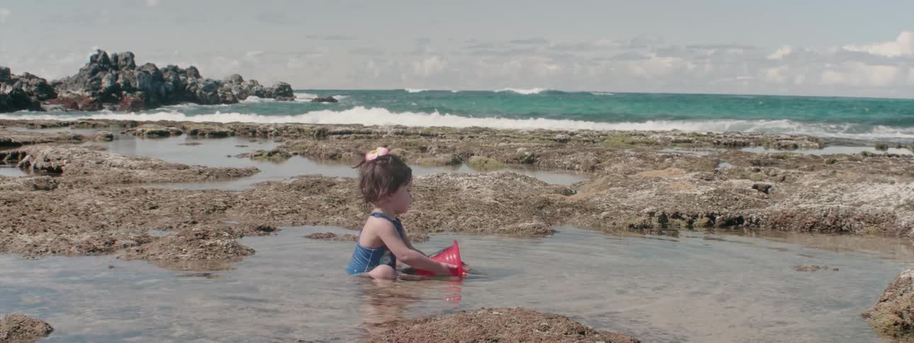 A young girl plays on a beach
