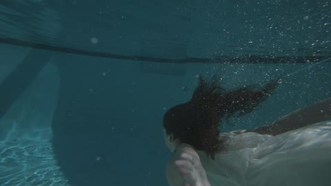 A Dark Haired Woman Swims In Her Pool A Dark Haired Woman Swims In Her Pool