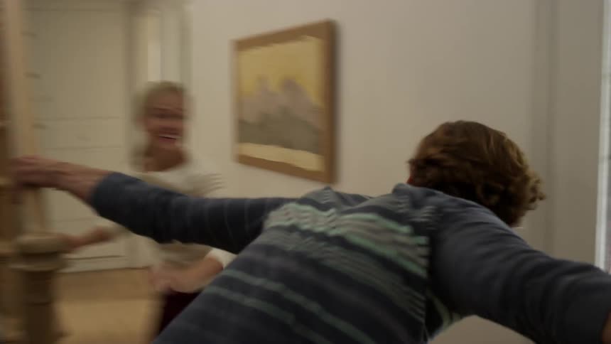 A young couple running down stairs and laughing
