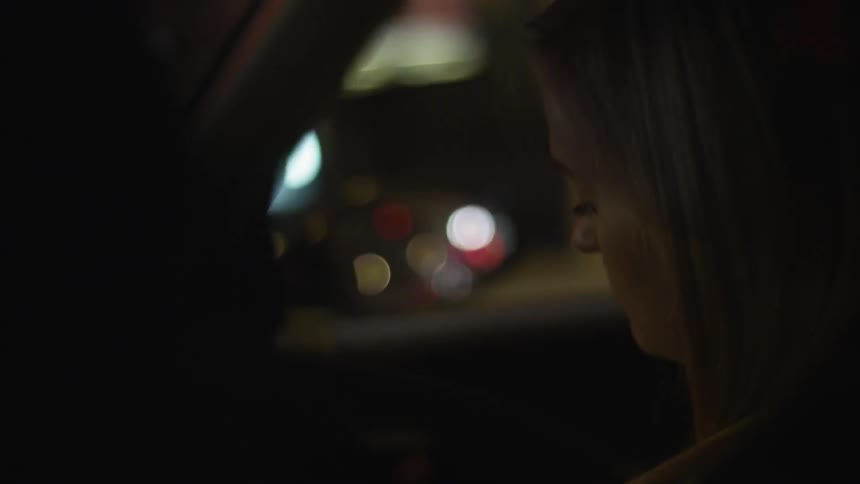 Woman sitting in a moving car at night