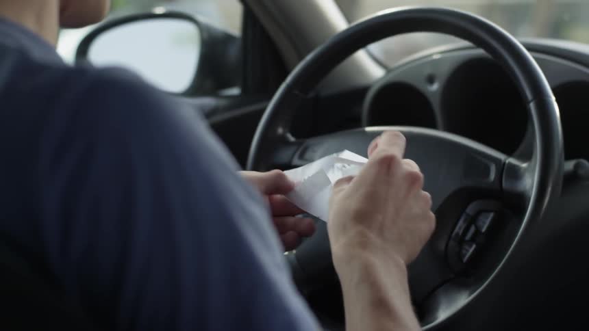 Man sits in a car and finds a note