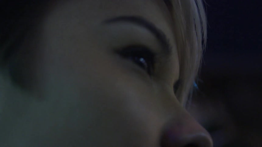 Woman standing in a dark area with lights flashing