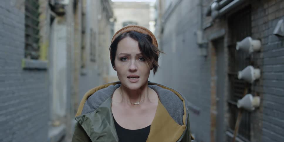 Woman looks worried while walking in an alley