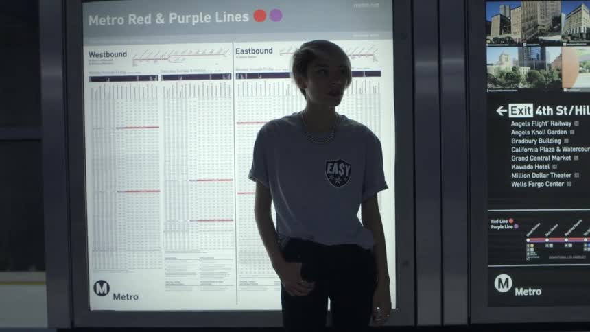 A woman stands in front of a public transit schedule