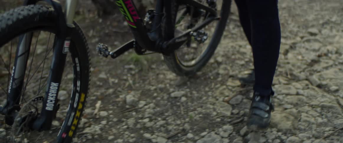 Person walks mountain bike along a trail