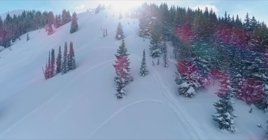 The sun shines on a snow covered mountain slope