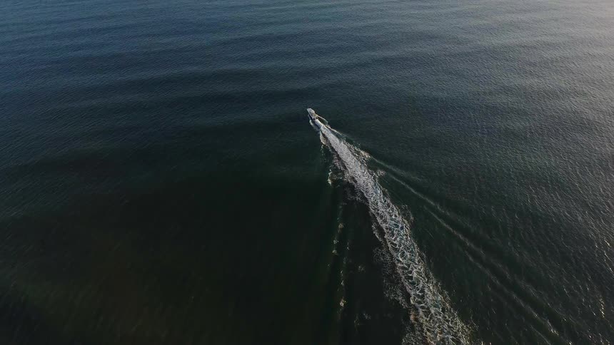 A boat speeds off on the water