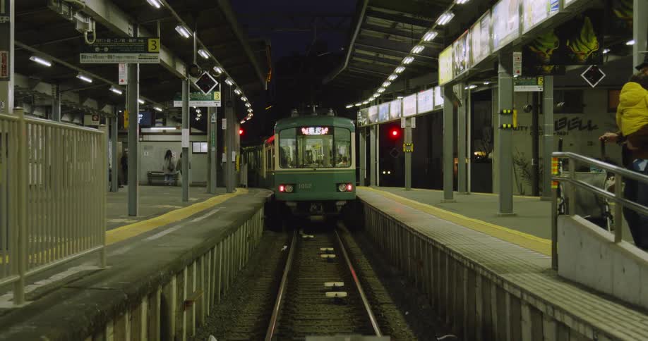 A commuter train is pulling away from a station in an asian city