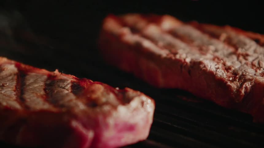 The steaks are cooking on the grill
