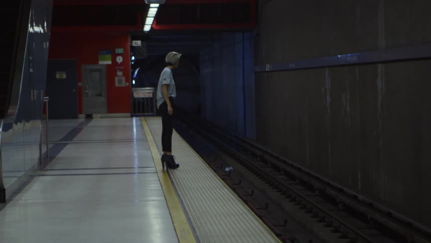 Woman standing on a subway platform waiting