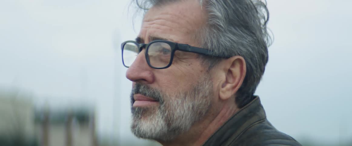 Man in glasses looks sad outside