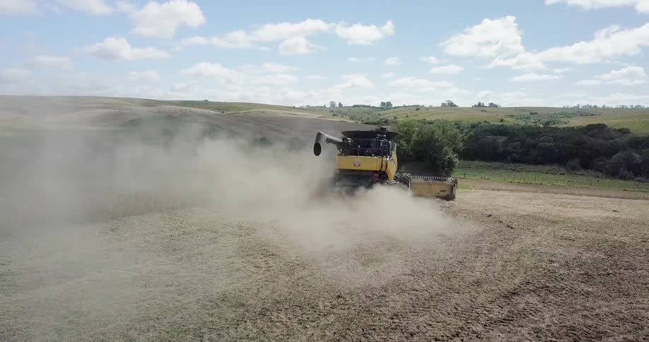 Farm equipment is operated in a dusty field