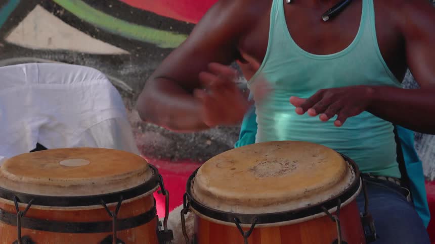 A black man plays the congas