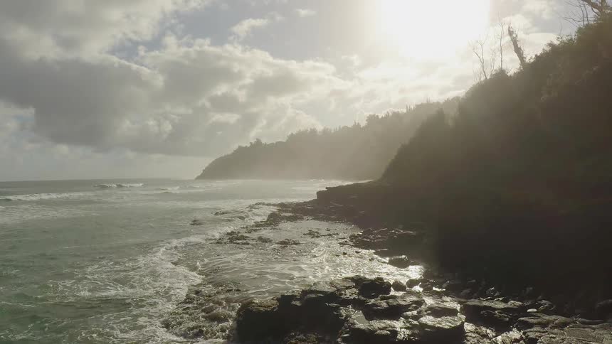 The waves are hitting the shore at sunrise