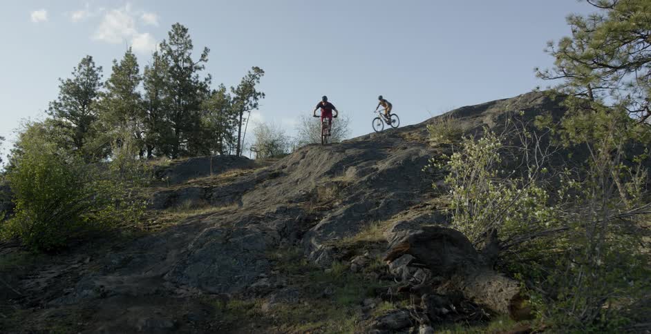 A pair of bikers are riding down a steep hill