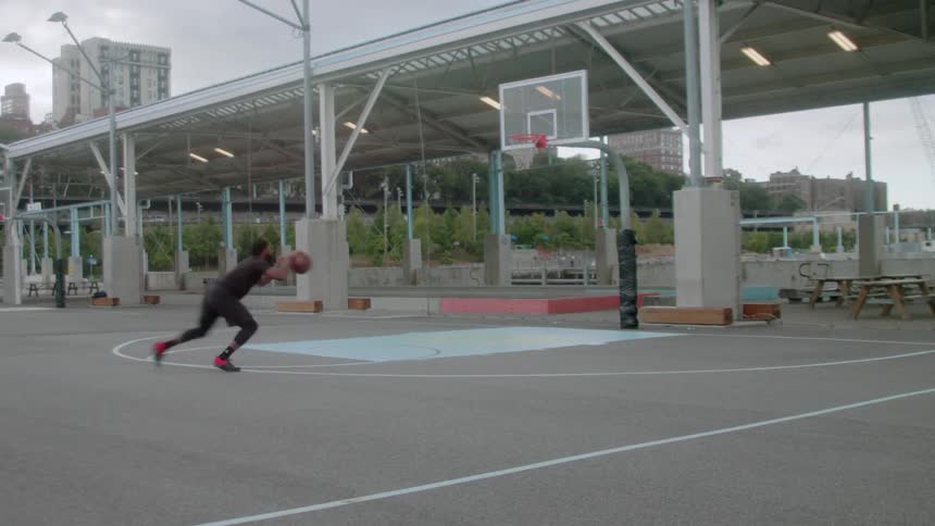 Man plays basketball on an outdoor court