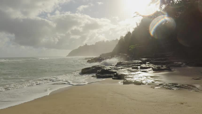 Water crashes up onto the beach on a sunny day