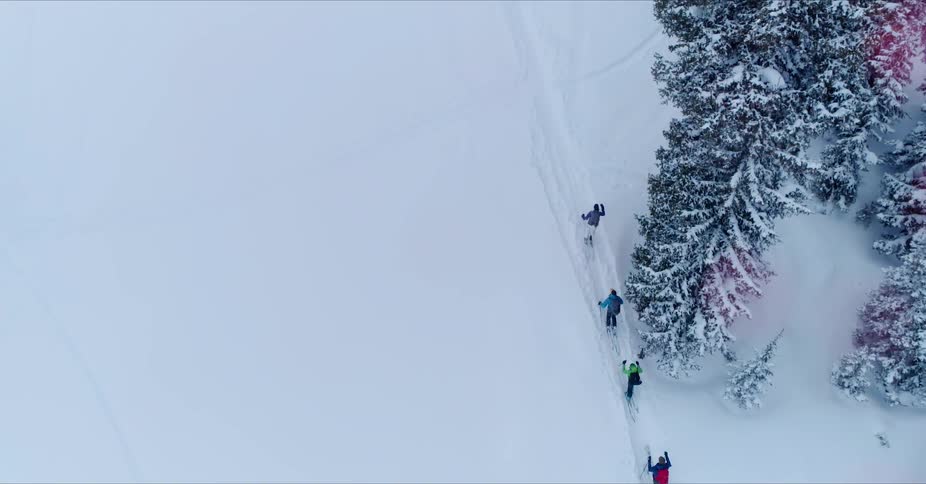 Skiers hike up a snowy mountainside