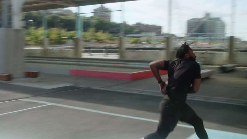 Man makes a shot with basketball on outdoor court in city