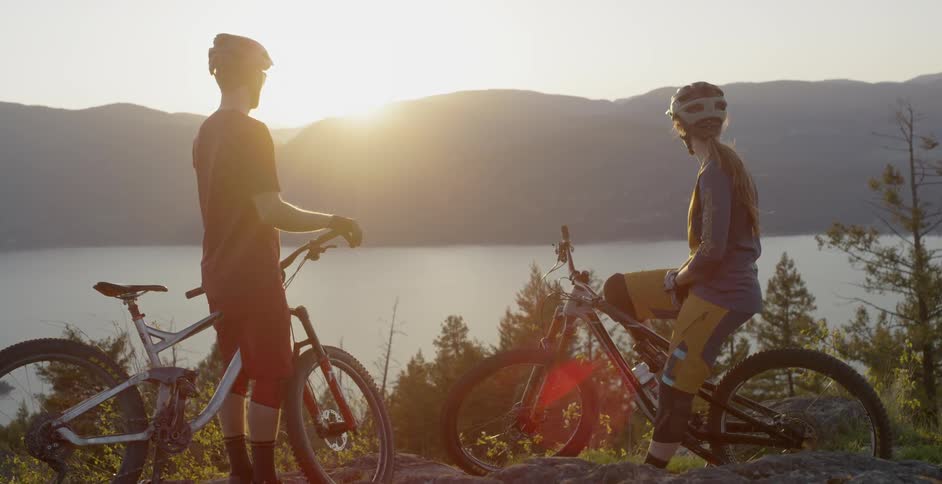 People standing with bikes overlooking a lake