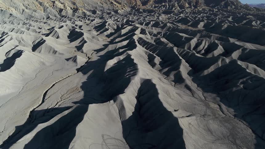 Tire tracks cover some of the slopes and ridges of dunes