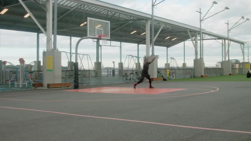 A man practices guarding and defending on an empty basketball court
