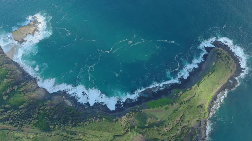 Ocean waves break against the rocks along the coast