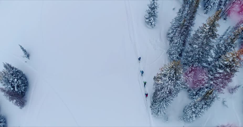 People are traveling up the slope in the snow