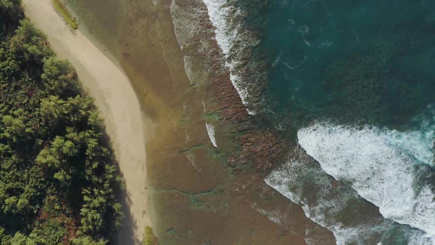 Ocean waves washing onto shore on sunny day